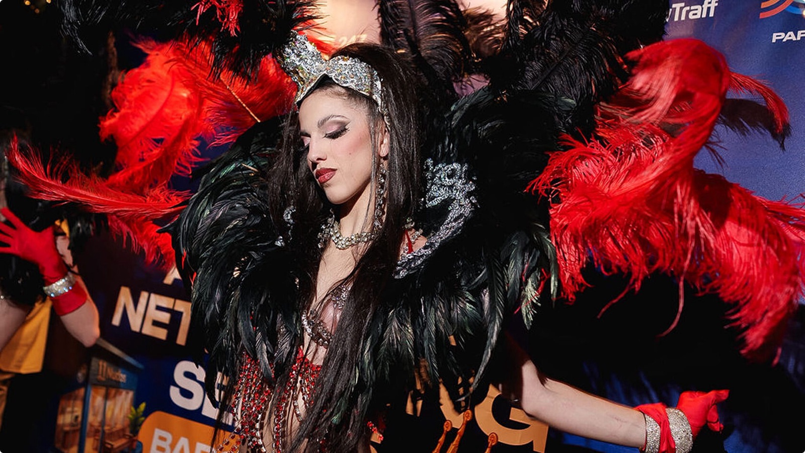 A dancer in a red and black feather costume